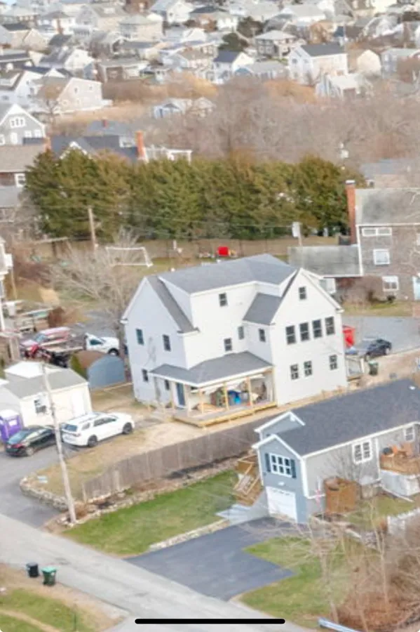 Aerial view of a finished white home in a coastal neighborhood